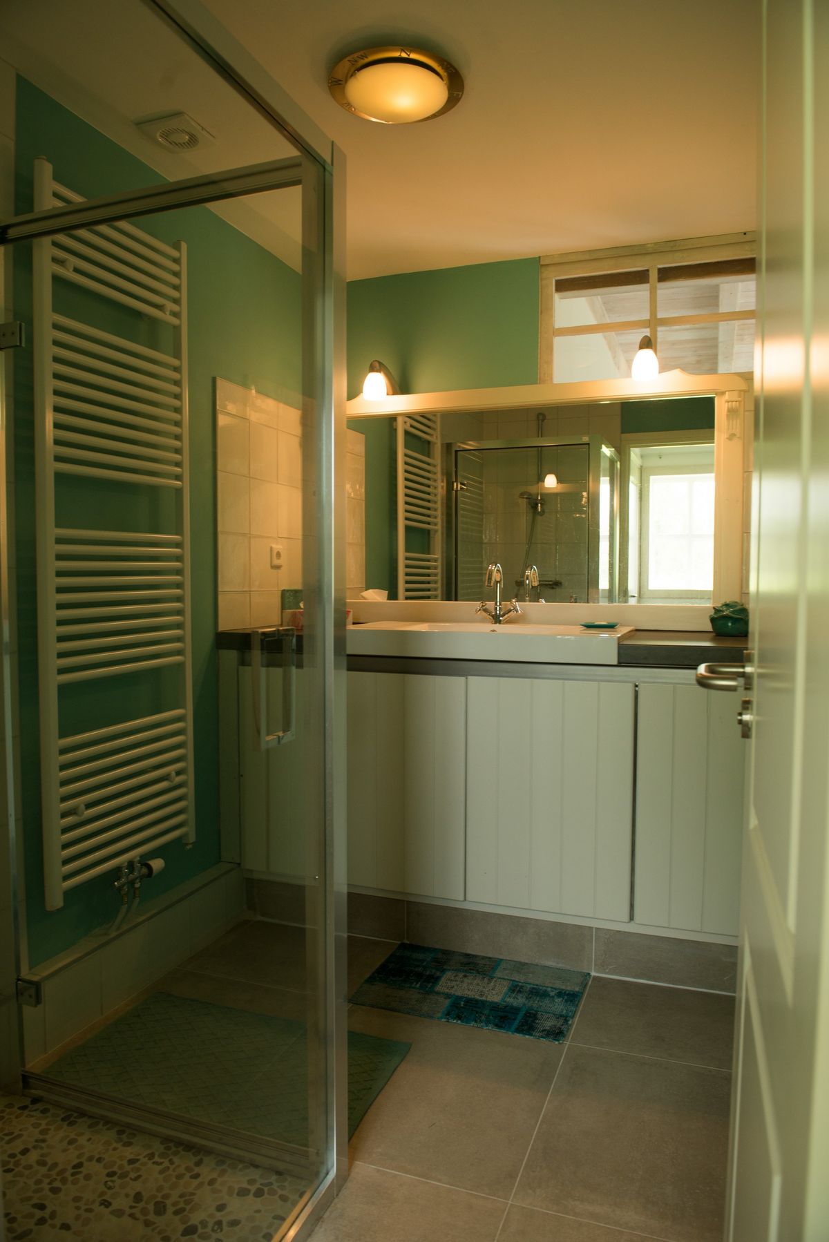 Badkamer met inloopdouche, verwarmde handdoekrek en wastafelmeubel – Zeeuwshuisje vakantiewoning, Koudekerke