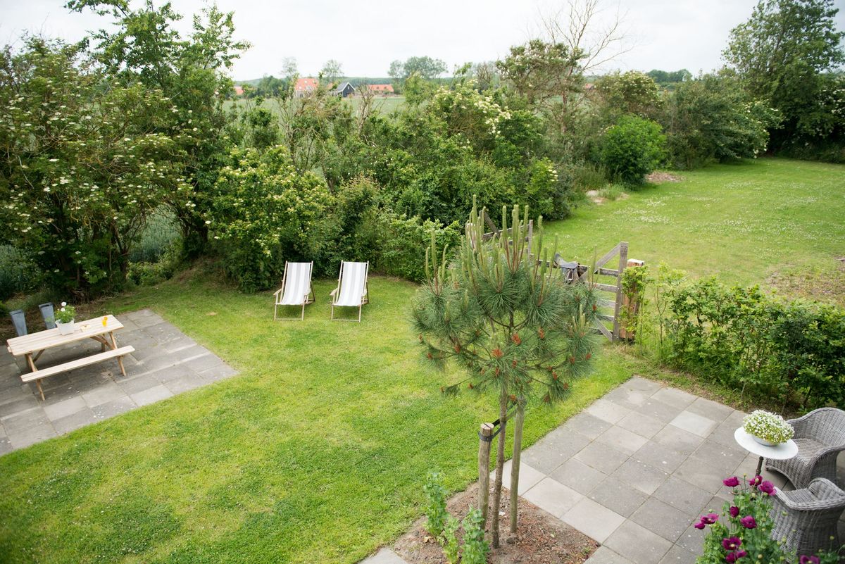 Tuin met gazon, picknickhoek en terras – Zeeuwshuisje vakantiewoning, Koudekerke